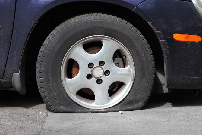 A close up of a flat tire on a car