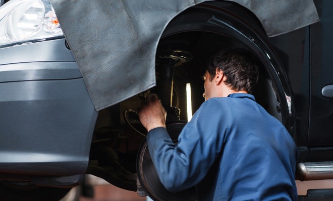 Mechanic working on suspension outside