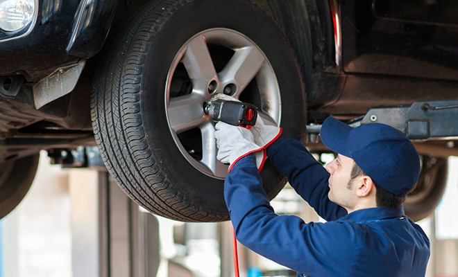 Mechanic-Removing-Lug-Nuts-On-Tire-Rim Mechanic-Removing-Lug-Nuts-On-Tire-Rim