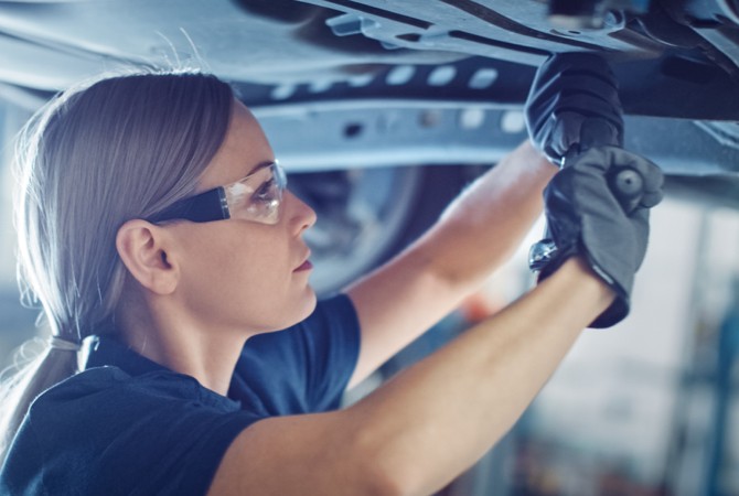 Mechanic working on the suspension under a vehicle