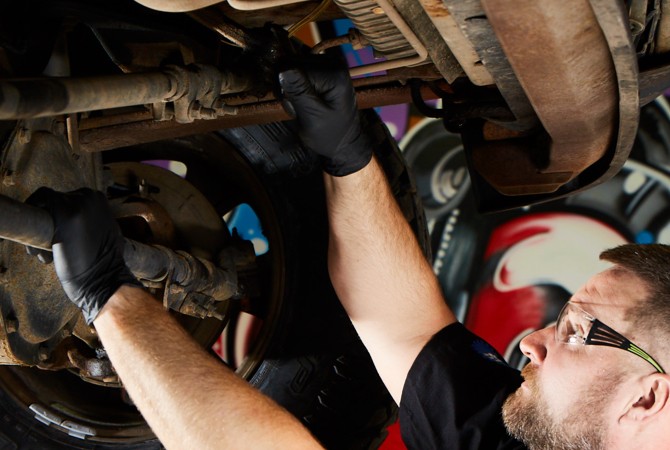 mechanic-working-on-car-suspension Mechanic working on car suspension
