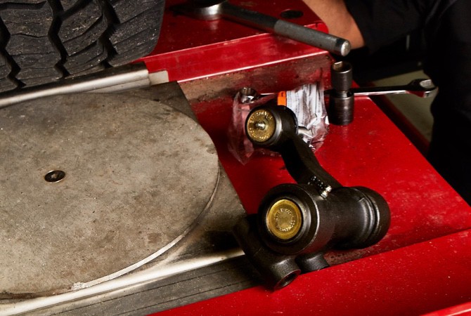 A MOOG control arm sitting on top of a red toolbox